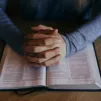 Les mains jointes d'un homme méditant la Parole de Dieu