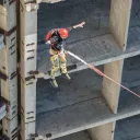 Un homme saute d'un bâtiment, attaché à une corde